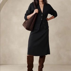 Black sweater skirt with slit in front.